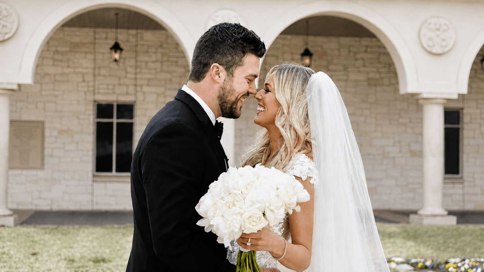 Wedding couple walking through an arched venue corridor